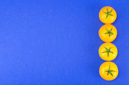 Bright yellow and red tomatoes on colored backgroundの写真素材