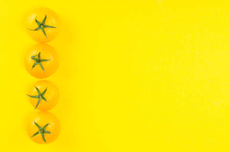 Bright yellow and red tomatoes on colored backgroundの写真素材