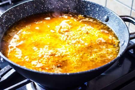 Preparation of pilaf with lamb in frying pan.