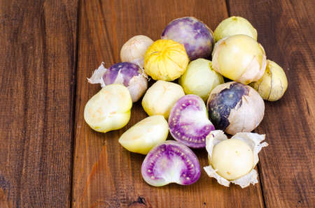 Ripe tomatillo (Physalis, Mexican husk tomato) on wooden table. Studio Photo