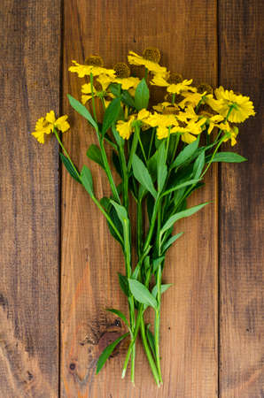Bouquet with yellow flowers on wooden tableの写真素材