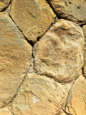 Texture, background, wall of large natural, untreated stones. Studio Photo