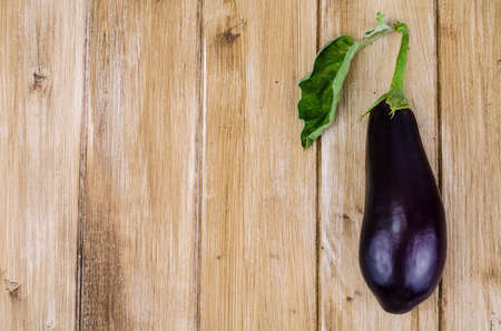 Ripe purple aubergine on wooden background.の写真素材