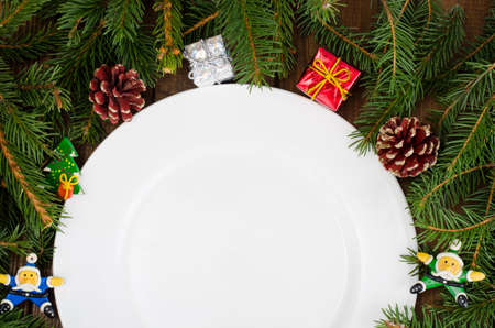 Christmas ornaments around white plate and spruce branches,  Christmas themeの写真素材