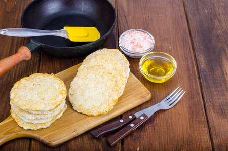 Frozen raw potato pancakes on cutting board for cooking. Studio Photo