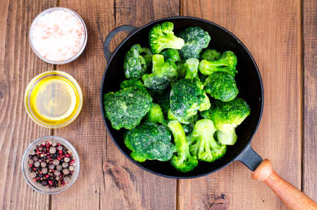 Cast iron pan with frozen broccoli for cooking. Studio Photoの写真素材