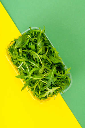 Fresh green arugula in package on color background. Studio Photoの写真素材