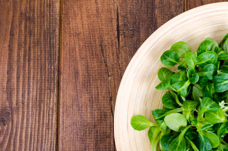 Corn salad and spinach leaves on wooden plate.の写真素材
