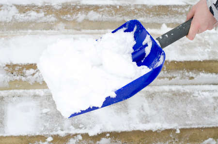 Man cleaning snow with shovel in winterの写真素材