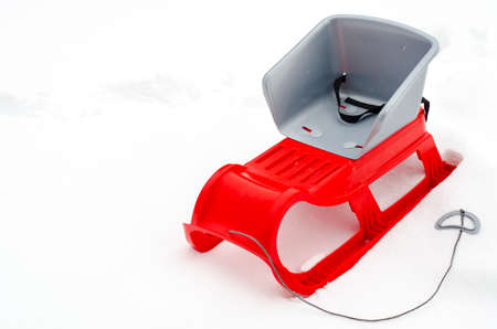 Red children sledge on white snow background.の写真素材