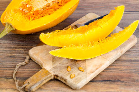 Sliced ripe pumpkin on wooden table.の写真素材