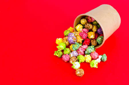 Colorful popcorn on red backgroundの写真素材