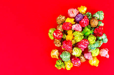 Colorful popcorn on red backgroundの写真素材