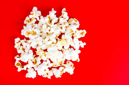 White and glazed popcorn on red backgroundの写真素材