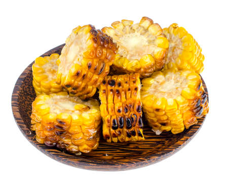 Slices of grilled corn on wooden plate.の写真素材