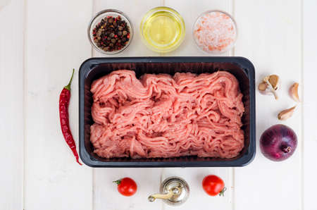 Minced meat in black plastic container. Studio Photo