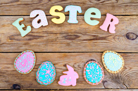 Homemade cookies in form letters EASTER and eggs on old wooden backgroun. Studio Photo