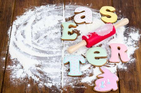 Homemade cookies in form letters EASTER and eggs on old wooden backgroun. Studio Photoの写真素材