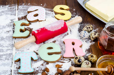 Homemade cookies in form letters EASTER and eggs on old wooden backgroun. Studio Photo