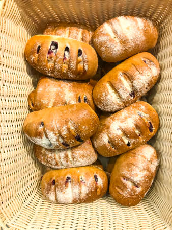 Baskets with buns, bread and cakes in store. Studio Photo