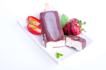 Ice cream in chocolate icing on stick with strawberries and mint. Studio Photoの写真素材