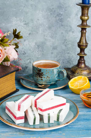 Composition on table with marshmallows, cup of tea.