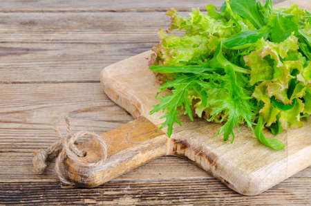 Green mix of different leaves on wooden board, vegetarian food, dietの写真素材