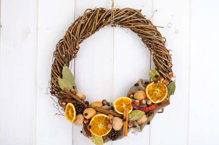 Christmas wreath of natural materials on white wooden wall