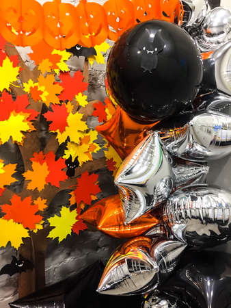 Top viev yellow ghosts pumpkins with colorful autumn leaves , silver and black toys, halloween conceptの写真素材