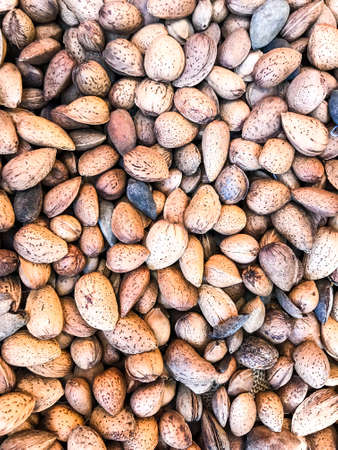 Unpeeled almonds in wicker basketの写真素材