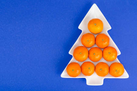 Bright orange ripe juicy tangerines in white plate, Christmas and New Year. Studio Photoの写真素材