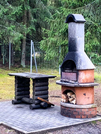 Barbecue stove with wood, playground, trees, picnic area.の写真素材