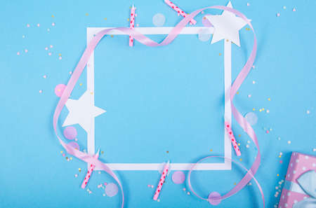 Party Holiday Background with ribbon, stars, birthday candles, gift box empty frame and confetti on blue background. Studio Photoの写真素材