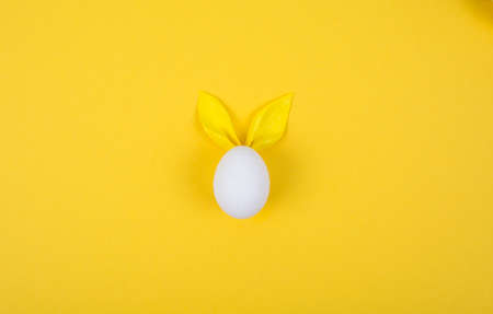 Egg with paper ears in the shape of an Easter bunny. Happy Easter Concept Card Postaer Background....