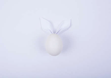 Egg with paper ears in the shape of an Easter bunny. Happy Easter Concept Card Postaer Background. Studio Photoの写真素材