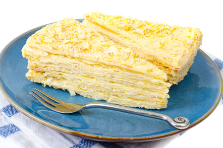 Plate with slice of homemade puff pastry with cream. Photo