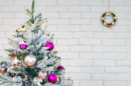 Fragment of decorated Christmas tree on brick wall background.の写真素材