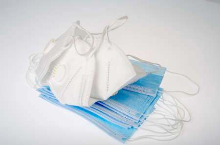 Blue medical disposable masks and white respirators - protection against coronavirus. Studio Photo