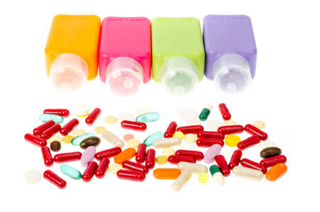 Multi-colored plastic bottles, containers with pills and capsules isolated on white background....