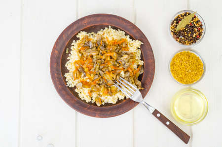 Boiled bulgur groats with stewed vegetables and mushrooms, vegetarian food. Studio Photoの写真素材