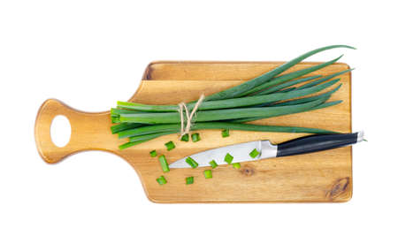 Wooden kitchen cutting board for slicing fresh green onions. Studio Photo