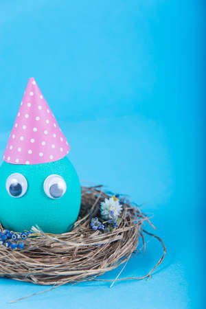 Colorful background with Easter funny cute egg on blue background. Happy Easter concept. Can be used as poster, background, holiday card. Studio Photoの写真素材