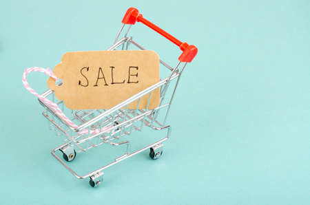 Seasonal sales. Shopping cart shopping cart on bright background. Studio Photoの写真素材