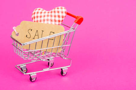 Seasonal sales. Shopping cart shopping cart on bright background. Studio Photoの写真素材
