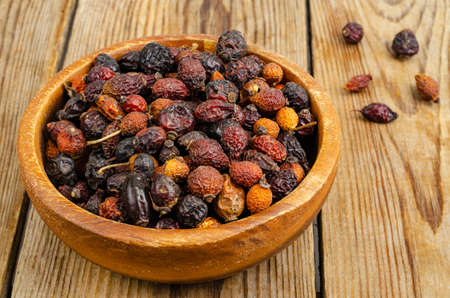 Dried rose hips in wooden bowl, natural vitamin C. Studio Photoの写真素材