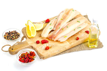 Raw pollock fillet on kitchen cutting wooden board. Studio Photoの写真素材