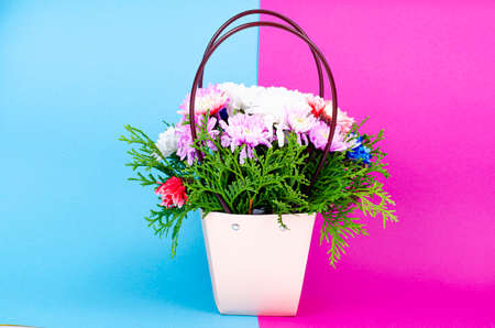Decorative chrysanthemum flowers in basket on colored background. Studio Photoの写真素材