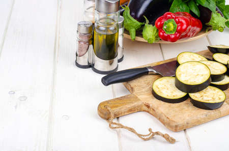 Sliced eggplant slices on wooden board, seasonal vegetables for cooking. Studio Photo.の写真素材