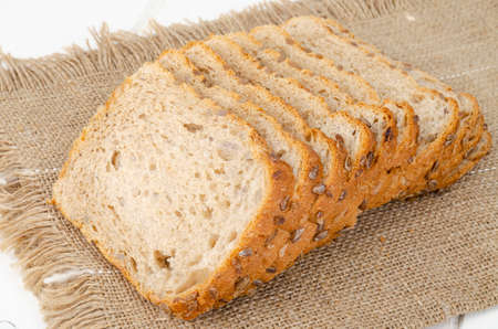 Sliced whole grain bread with sunflower seeds, square shape. Studio Photo.