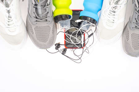 Running track with sneakers and bottle of water on black background. Exercise tools for health. Studio Photo.の写真素材